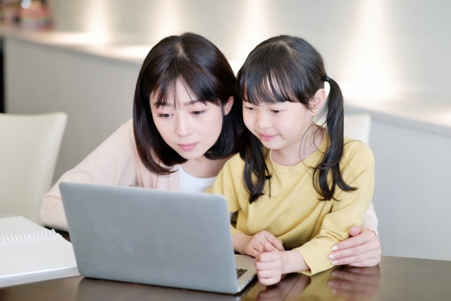 Parents and children watching piano lessons on a computer